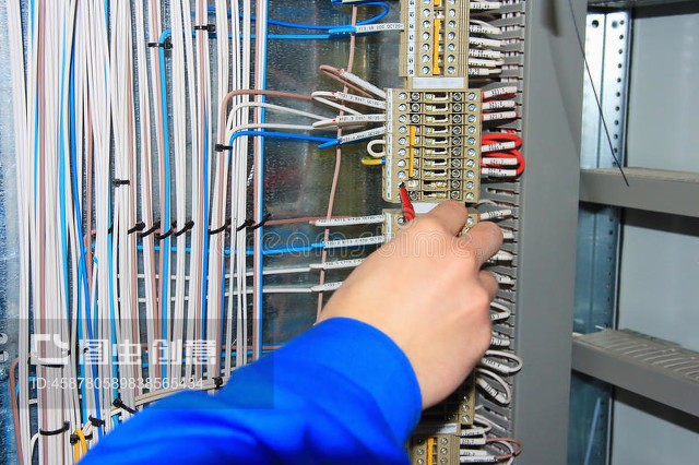 電工的手對電器柜的端子進行接線。The electrician`s hand carries out wiring to the terminals of the electrical cabinet.
